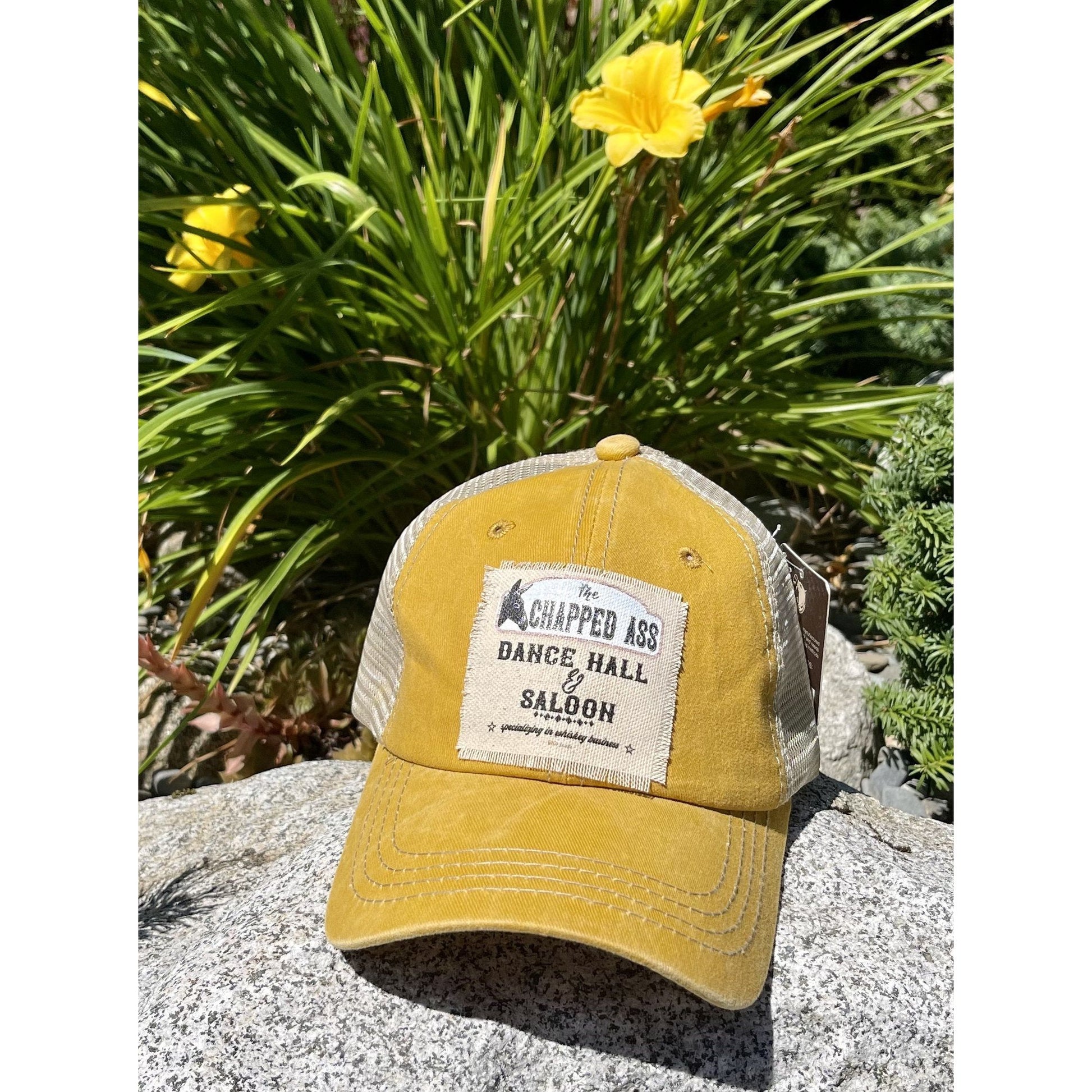 Yellow Trucker hat featuring the chapped ass dance hall and saloon with a donkey on it